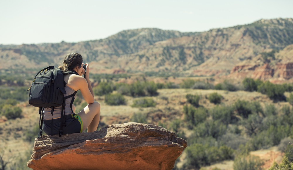 Female Backpacker Taking Photograph of Canyon
